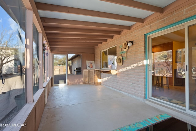 unfurnished sunroom featuring beamed ceiling