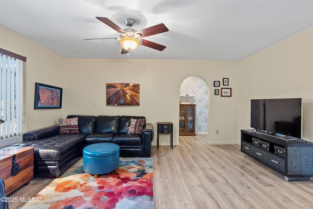 living room featuring wood finished floors, a ceiling fan, and baseboards