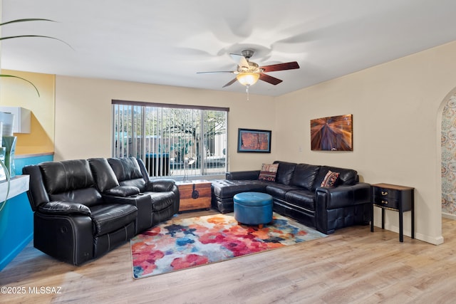 living room with baseboards, ceiling fan, and light wood finished floors