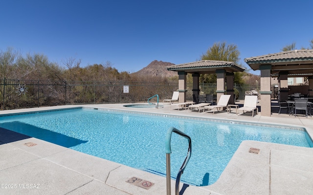 pool featuring a gazebo, fence, a mountain view, and a patio