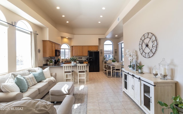 living room featuring a healthy amount of sunlight, light tile patterned floors, visible vents, and recessed lighting