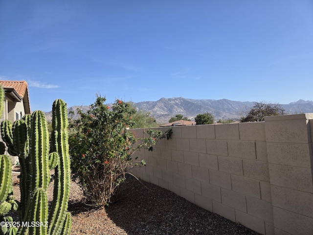 view of yard featuring fence and a mountain view