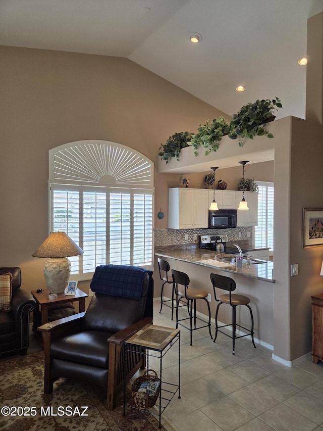 living area with vaulted ceiling, light tile patterned flooring, baseboards, and recessed lighting