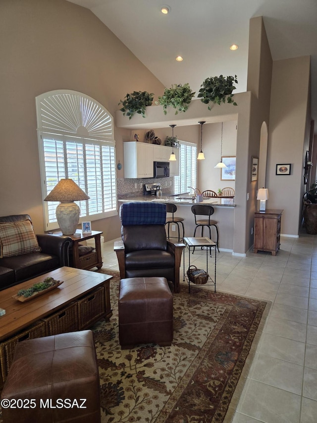 living area featuring high vaulted ceiling, recessed lighting, baseboards, and light tile patterned floors