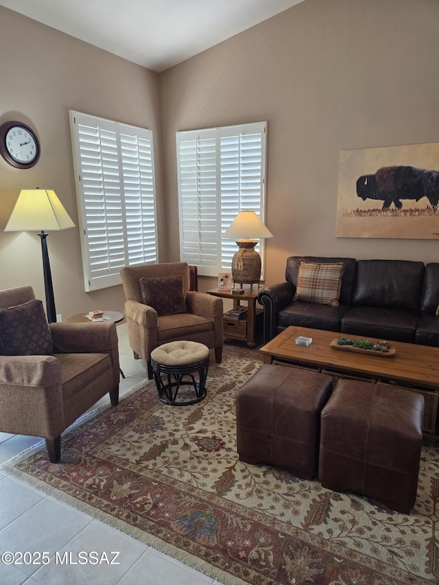 living area featuring lofted ceiling and tile patterned flooring