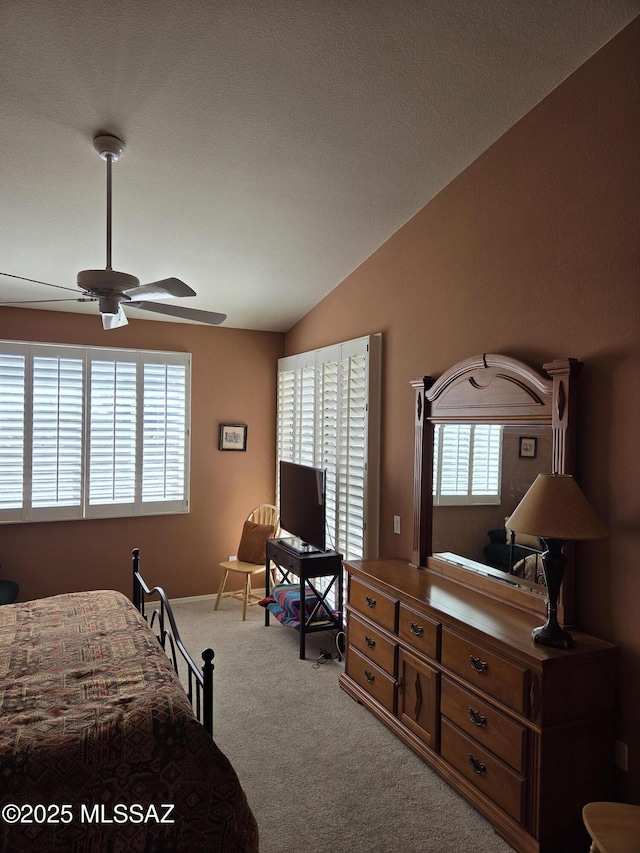 carpeted bedroom featuring ceiling fan, baseboards, and vaulted ceiling