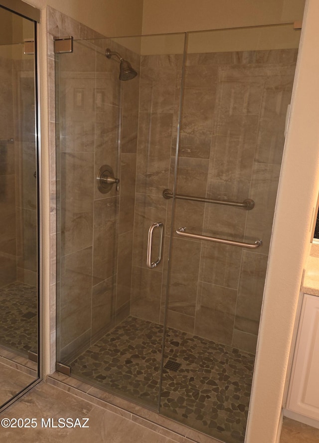 full bath with a shower stall and tile patterned floors