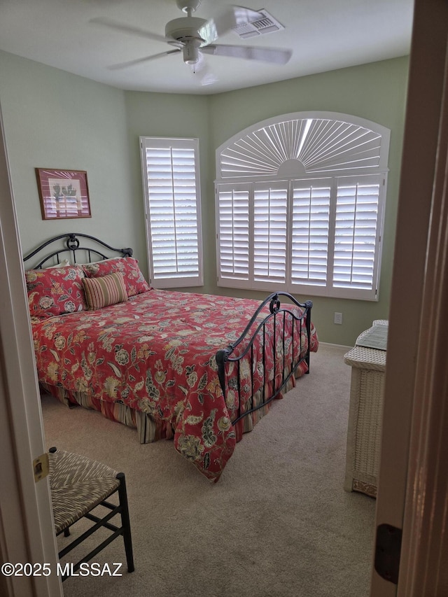 bedroom with carpet floors, visible vents, and a ceiling fan