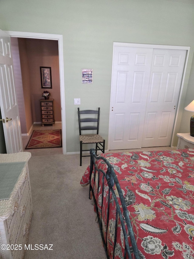 carpeted bedroom with a closet and baseboards