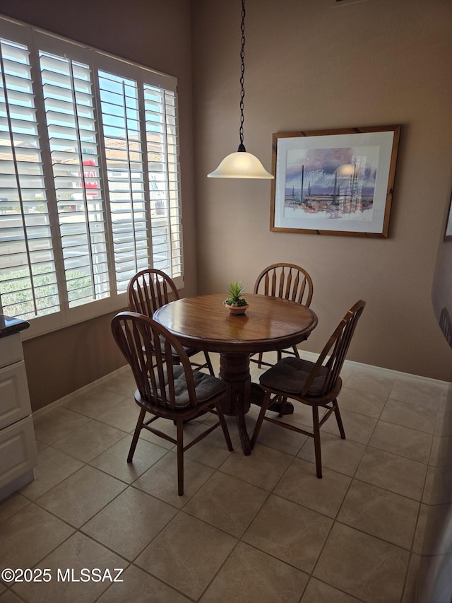 dining space featuring baseboards and light tile patterned floors