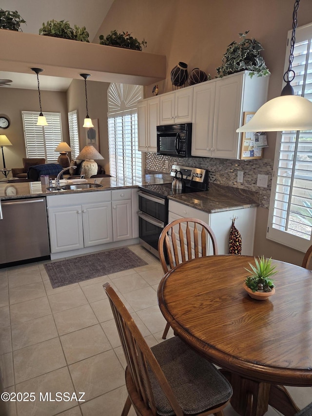 kitchen featuring stainless steel appliances, backsplash, white cabinets, a sink, and light tile patterned flooring