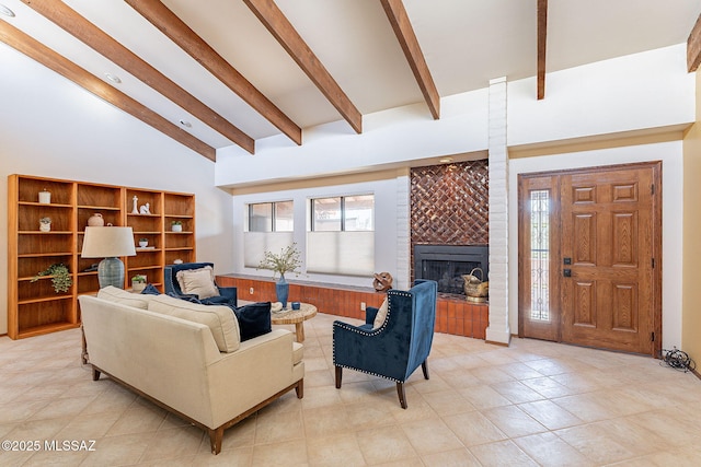 living room with high vaulted ceiling, a brick fireplace, and beam ceiling