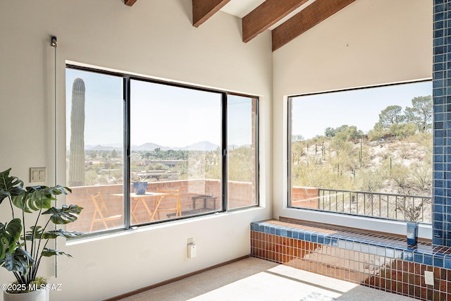 sunroom featuring beam ceiling and a mountain view