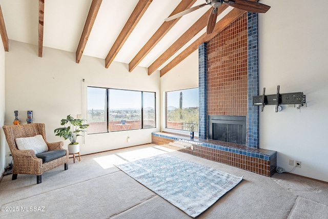 interior space with ceiling fan, a fireplace, high vaulted ceiling, and beam ceiling