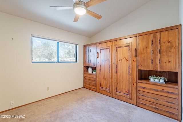 unfurnished bedroom with vaulted ceiling, carpet floors, ceiling fan, and baseboards