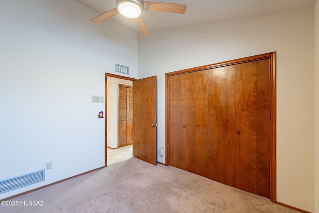 unfurnished bedroom with a ceiling fan, carpet, visible vents, and a closet