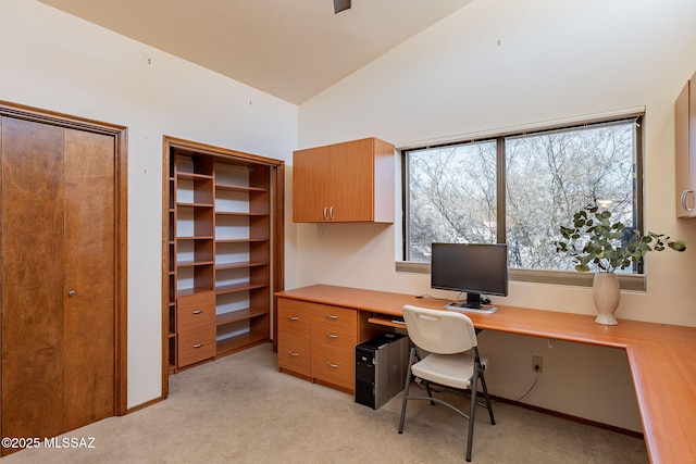 office with lofted ceiling and light carpet