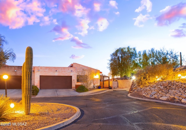 exterior space featuring a garage, a gate, driveway, and fence