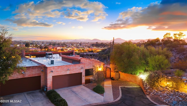 view of front of home featuring a garage, fence, a mountain view, and concrete driveway