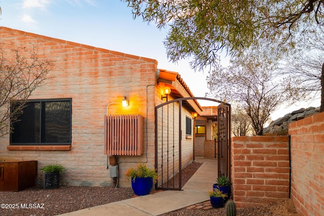 view of property exterior with a fenced front yard and a gate