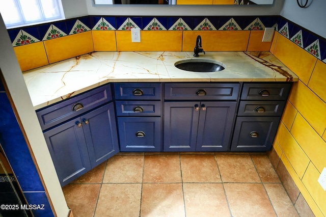 bathroom with tile patterned flooring, backsplash, and a sink