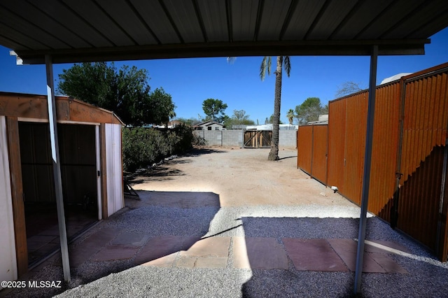 view of patio featuring a fenced backyard, a shed, and an outdoor structure