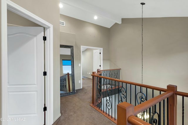 hallway with visible vents, lofted ceiling with beams, carpet flooring, an upstairs landing, and baseboards