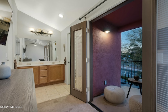 bathroom with vaulted ceiling, vanity, and tile patterned floors