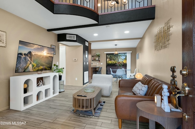 living room with baseboards, wood tiled floor, visible vents, and beam ceiling