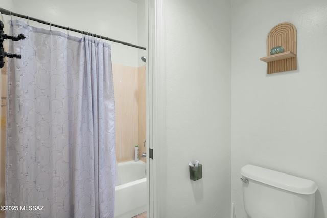 bathroom featuring shower / tub combo and toilet