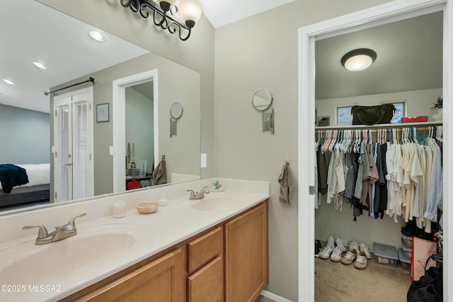 full bathroom with recessed lighting, double vanity, a sink, and ensuite bathroom