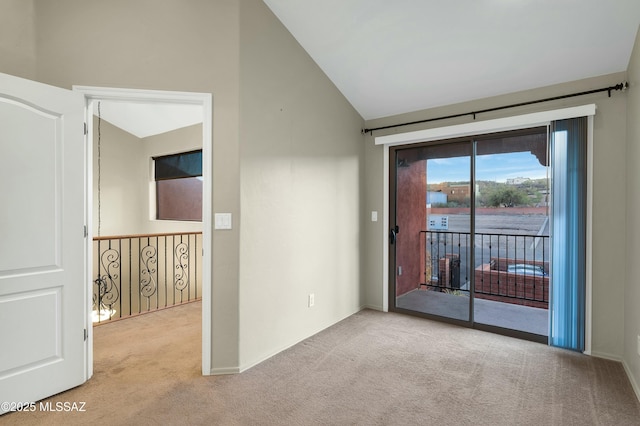 carpeted spare room featuring vaulted ceiling and baseboards