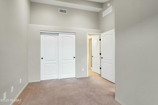 unfurnished bedroom with a closet, carpet flooring, visible vents, and baseboards