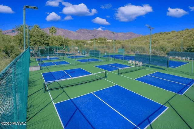 view of tennis court featuring fence and a mountain view