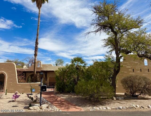 view of front of property featuring a fenced front yard, a gate, and stucco siding