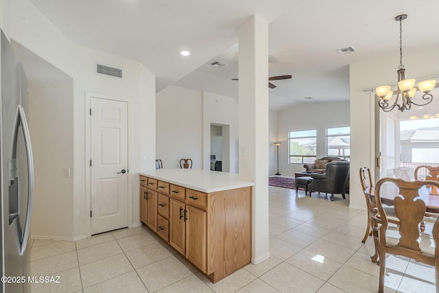 kitchen featuring light countertops, stainless steel fridge, visible vents, and ceiling fan with notable chandelier