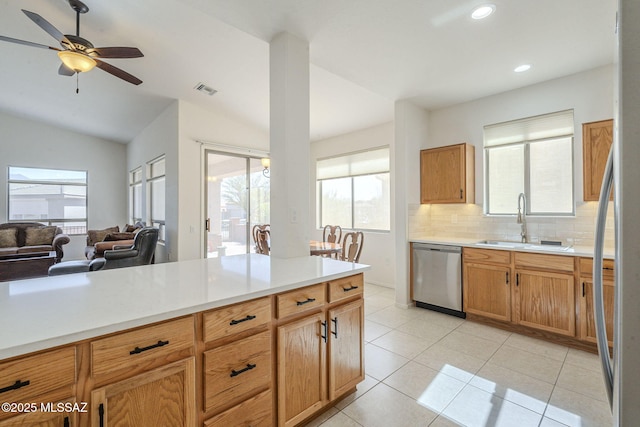 kitchen with light tile patterned floors, a sink, visible vents, stainless steel dishwasher, and decorative backsplash