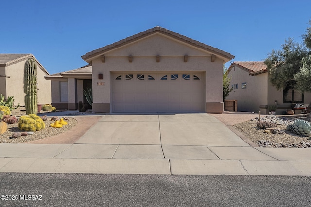 view of front of house with an attached garage, driveway, a tile roof, and stucco siding