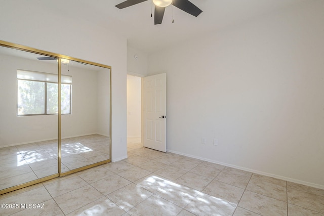 unfurnished bedroom with tile patterned flooring, a closet, ceiling fan, and baseboards