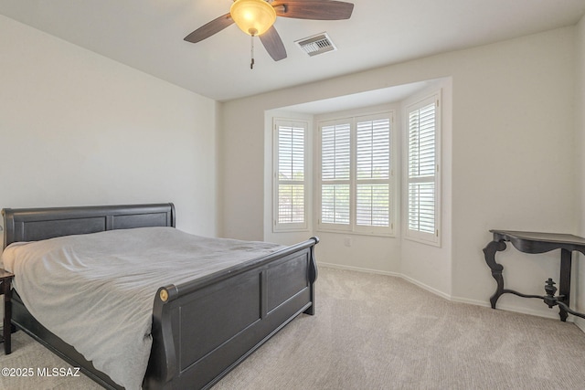 bedroom featuring baseboards, ceiling fan, visible vents, and light colored carpet