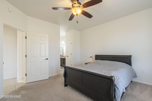 bedroom featuring light colored carpet, connected bathroom, baseboards, and ceiling fan