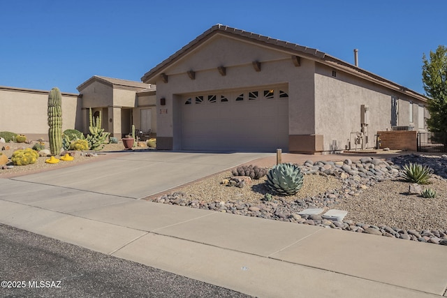 view of front of home featuring a garage, driveway, and stucco siding