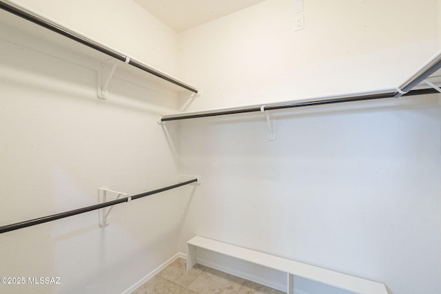 walk in closet with light tile patterned floors