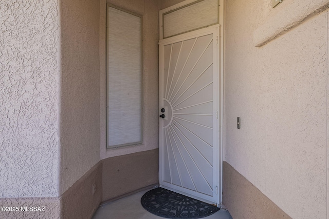 doorway to property featuring stucco siding