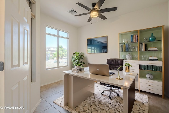 home office with visible vents, ceiling fan, baseboards, and light tile patterned flooring