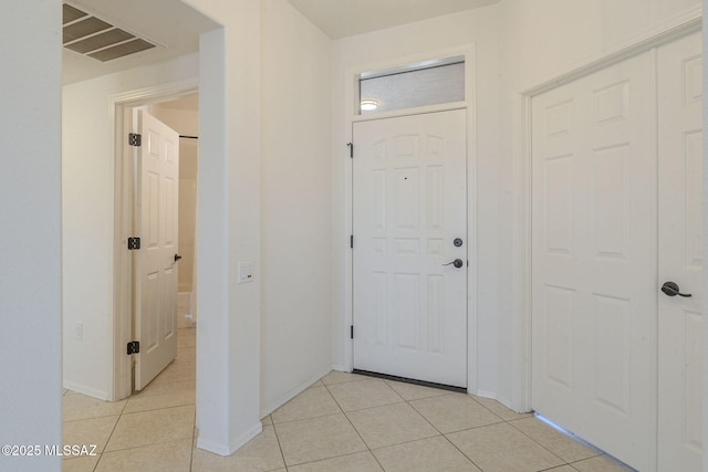 foyer entrance featuring light tile patterned floors, visible vents, and baseboards