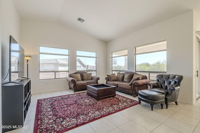 living room with baseboards, visible vents, vaulted ceiling, and light tile patterned flooring