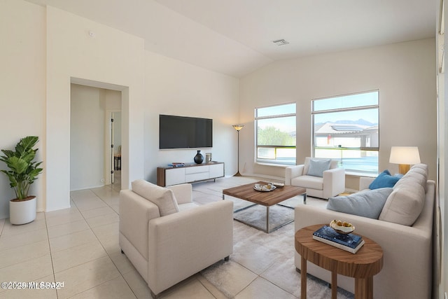 living room featuring visible vents, vaulted ceiling, and light tile patterned floors