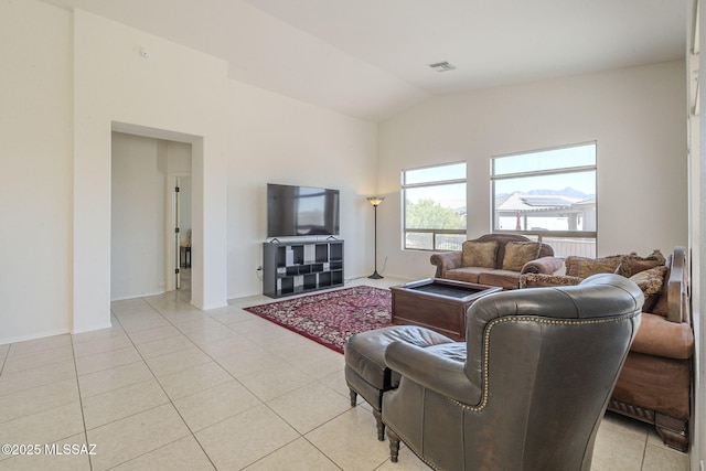 living area featuring lofted ceiling, light tile patterned floors, and visible vents