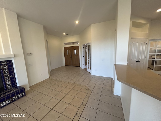 entryway featuring a tile fireplace, recessed lighting, and light tile patterned floors